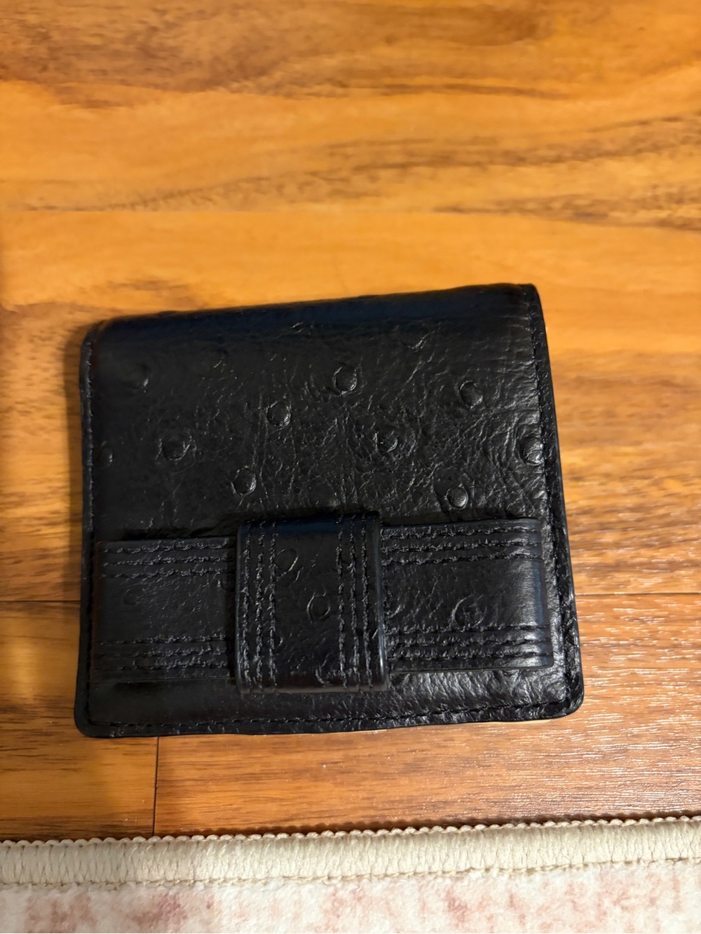 Kate Spade black ostrich embossed textured leather wallet.